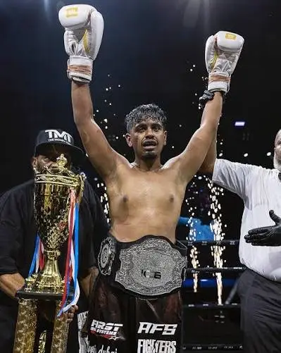 Rashed Belhasa raising his gloves with his championship belt and trophy